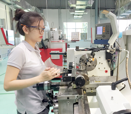 Nguyễn Hoàng Trúc Kiều thành thạo với các thao tác máy cắt gọt kim loại CNC. Ảnh: C.Nghĩa