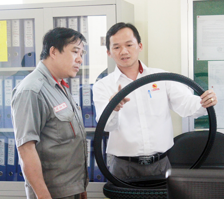 Anh Nguyễn Duy Nghĩa (phải) kiểm tra chất lượng sản phẩm tại phòng làm việc.