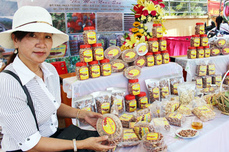 Bà Trần Thị Diệu Cương giới thiệu sản phẩm hạt điều rang muối tại hội chợ nông nghiệp ở huyện Xuân Lộc.