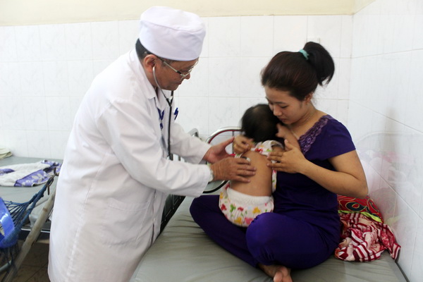 Bác sĩ Khoa nhiễm Bệnh viện nhi đồng Đồng Nai khám bệnh cho một trẻ bị tay chân miệng. 