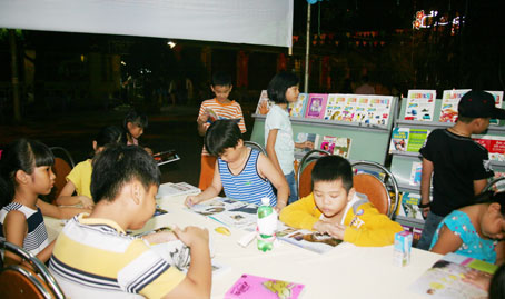 Trẻ em đọc sách tại khu vực phố đi bộ Nguyễn Văn Trị do Thư viện TP.Biên Hòa tổ chức. Ảnh: V.TRUYÊN