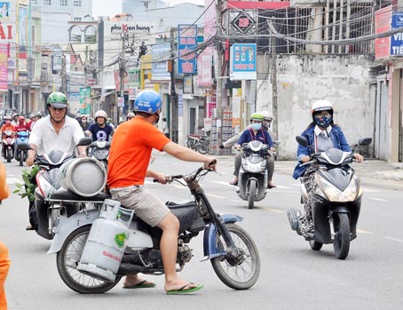 Người thanh niên điều khiển xe máy cũ, không đảm bảo an toàn chở bình gas chạy trên đường Phạm Văn Thuận.