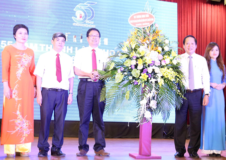 Đồng chí Trương Minh Tuấn, Ủy viên Trung ương Đảng, Bộ trưởng Bộ Thông tin - truyền thông, tặng hoa chúc mừng Khoa Báo chí. Ảnh: T.Phương