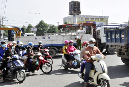 Lực lượng cảnh sát cơ động vất vả điều tiết ùn tắc giao thông tại khu vực vòng xoay Tân Phong. Ảnh: T.HẢI