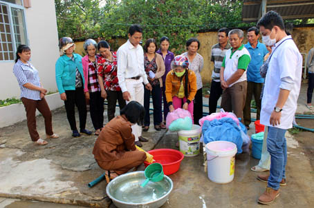 Nhân viên Trạm y tế xã Núi Tượng, huyện Tân Phú hướng dẫn người dân tẩm mùng hóa chất phòng chống muỗi gây bệnh sốt rét. Ảnh: N.Thư