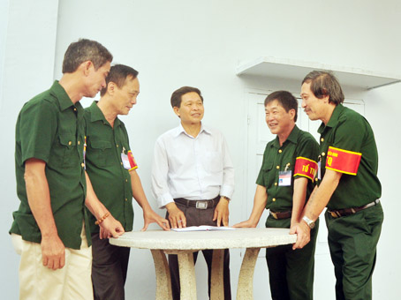 Phó chủ tịch Hội Cựu chiến binh xã Tam Phước Trần Văn Tam (giữa) trao đổi công việc với Tổ An ninh tự quản Chi hội 10, Hội Cựu chiến binh xã Tam Phước.