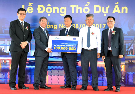Phó chủ tịch UBND tỉnh Nguyễn Quốc Hùng (thứ 2 từ trái qua) nhận 100 ngàn USD do chủ đầu tư dự án tặng cho Quỹ Khuyến học của tỉnh.