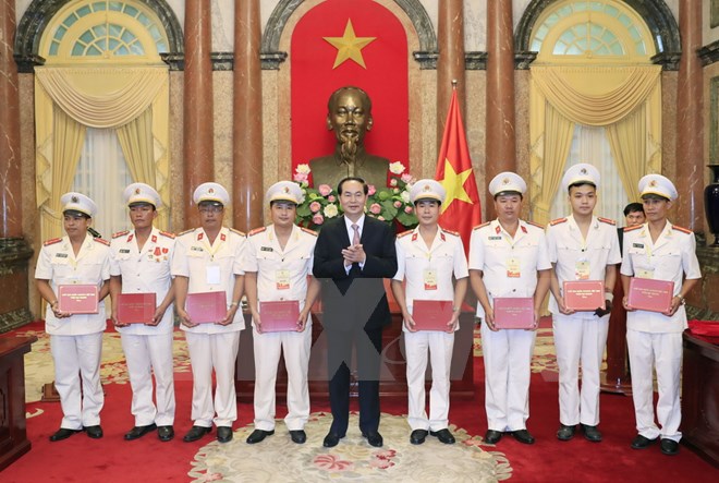 Chủ tịch nước Trần Đại Quang tặng quà cho các điể hình tiên tiến trong lực lượng Cảnh sát nhân dân tại buổi gặp mặt. (Ảnh: Nhan Sáng/TTXVN)