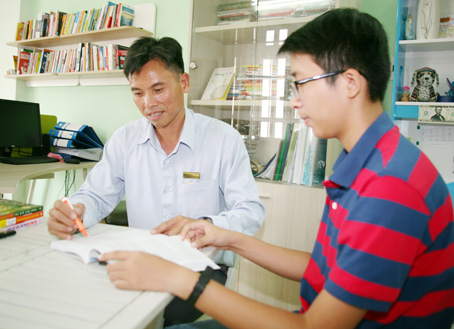 Ông Nguyễn Ngọc Tuấn (trái), Giám đốc Công ty cổ phần thuế kế toán Luật Việt Á (TP.Biên Hòa) cùng con trai đọc sách tại nhà. Ảnh: V.TRUYÊN