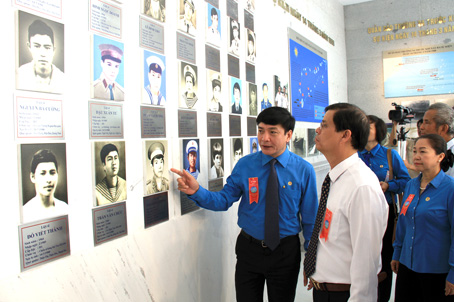 Ông Bùi Văn Cường, Chủ tịch Tổng liên đoàn Lao động Việt Nam (trái), giới thiệu với các đại biểu hình ảnh các liệt sĩ hy sinh tại Gạc Ma.