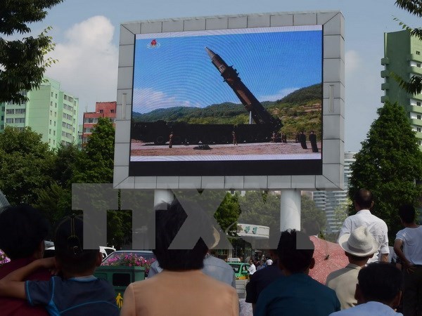 Người dân Triều Tiên theo dõi tin tức về vụ phóng tên lửa đạn đạo liên lục địa Hwasong-14 trên màn hình lớn gần một nhà ga xe lửa ở Bình Nhưỡng. (Nguồn: AFP/TTXVN)