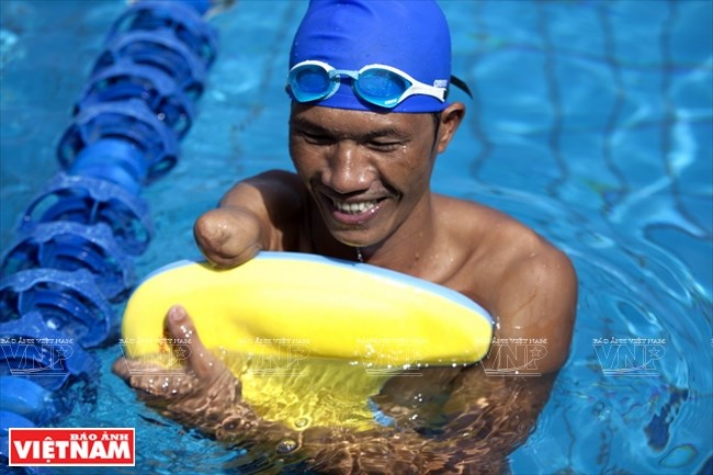 Nụ cười vui vẻ của vận động viên bơi khuyết tật Nguyễn Quang Vương,một học trò của thầy Cường, khi được thỏa đam mê bơi lội.
