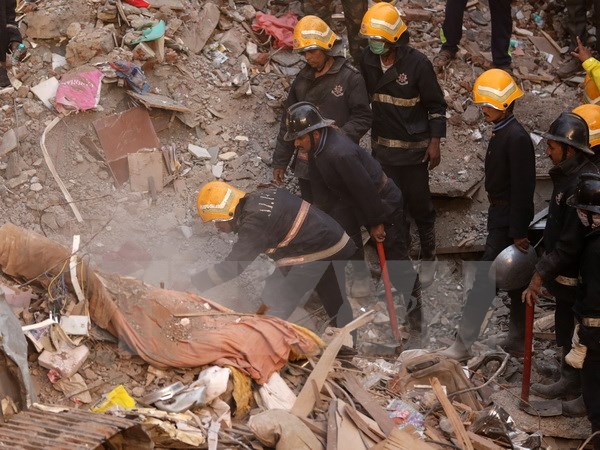 Nhân viên cứu hộ tìm kiếm nạn nhân bị vùi lấp dưới những đống đổ nát trong vụ sập nhà ở Mumbai. (Nguồn: EPA/TTXVN)