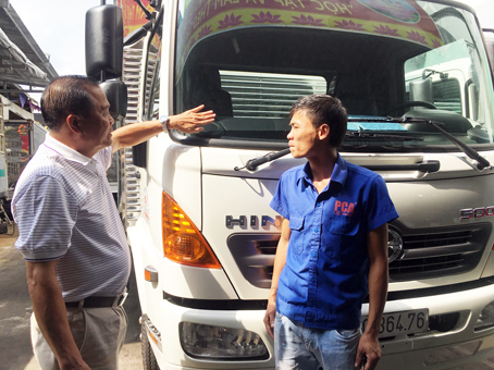 Đồng chí Nguyễn Xuân Cử (trái), Bí thư Chi bộ, Giám đốc Công ty TNHH vận tải đường bộ Phú Cường A, nhắc lái xe bảo quản xe tốt.
