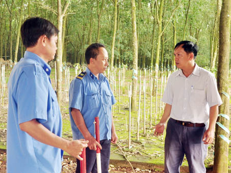 Đội trưởng Đội bảo vệ Nông trường cao su Cẩm Đường Trần Hữu Tài (bìa phải) kiểm tra một tổ trực. Ảnh: Đăng Tùng