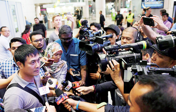 HLV Hữu Thắng trong vòng vây của giới truyền thông Malaysia tại sân bay Kuala Lumpur.