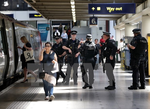 Cảnh sát đặc nhiệm Anh tuần tra tại sân ga khi chuyến tàu tới nhà ga Euston ở London. (Nguồn: AFP/TTXVN)