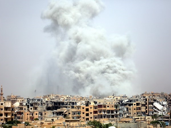 Khói bốc lên sau một cuộc không kích tại Raqa, Syria ngày 28/7. (Nguồn: AFP/TTXVN)