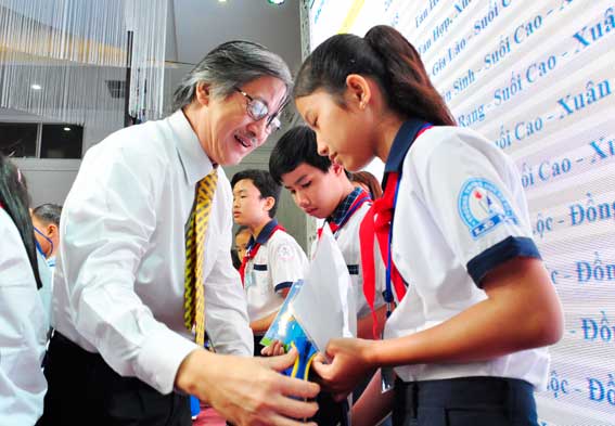 Ông Nguyễn Thành Quang, Phó tổng giám đốc Tổng công ty Bảo Việt nhân thọ (bìa phải) trao học bổng cho các em học sinh.