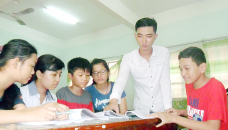 Nguyễn Tuấn Khanh (thứ 2 từ phải qua)dạy kèm các em nhỏ trong xóm trọ để kiếm tiền đi học. Ảnh: V.Truyên