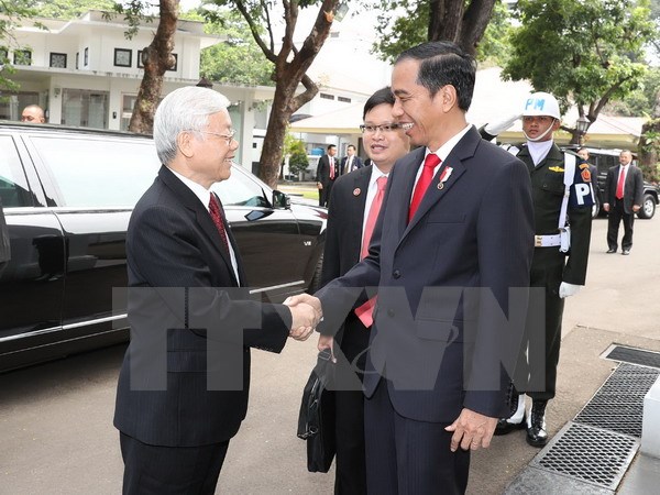 Tổng thống Indonesia Joko Widodo đón Tổng Bí thư Nguyễn Phú Trọng. (Ảnh: Trí Dũng/TTXVN)