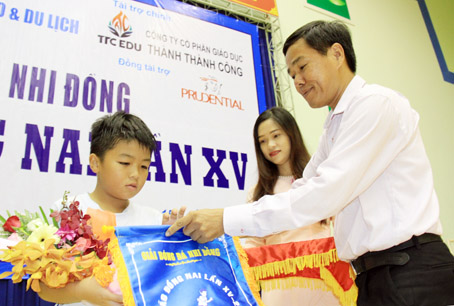 Ông Đinh Kim Tuấn, Phó tổng biên tập Báo Đồng Nai trao giải cho em Ngô Nguyễn Gia Huy.