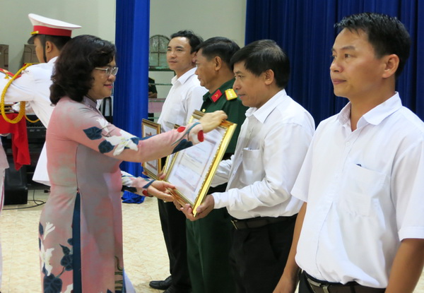 Phó chủ tịch UBND tỉnh Nguyễn Hoà Hiệp trao bằng khen UBND tỉnh cho các tập thể, cá nhân có thành tích xuất sắc trong thực hiện Luật Dân quân tự vệ. 