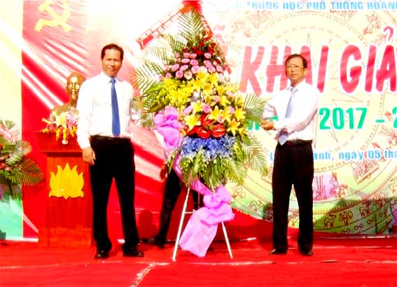 Bí thư Thị ủy Nguyễn Văn Nải (bên phải) tặng hoa chúc mừng Ban giam hiệu nhà trường.