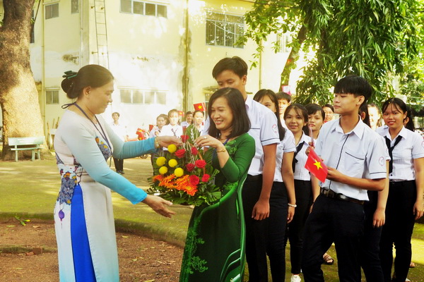 Hiệu trưởng trường THPT Vĩnh Cửu tặng hoa cho giáo viên chủ nhiệm và các em học sinh lớp 10 vừa nhập học (ảnh: Đăng Tùng)