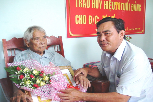 Đ/c Võ Tuấn Dũng, Phó bí thư Huyện ủy Tân Phú trao Huy hiệu 70 năm tuổi Đảng cho đ/c K’ Lư