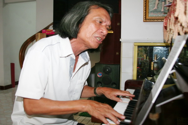 Nhạc sĩ Cao Hồng Sơn sáng tác bên cây đàn tại nhà. Ảnh: S.THAO