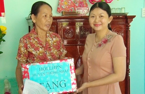 Chủ tịch hội LHPN huyện Thống Nhất-Trần Thị Kim Loan trao quà cho gia đình bà Hòa tại lễ trao nha.