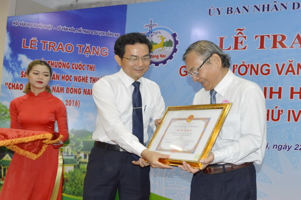 Phó chủ tịch UBND tỉnh Võ Văn Chánh trao giải A bộ môn văn nghệ dân gian cho ông Trần Quang Toại- đại diện nhóm tác giả.