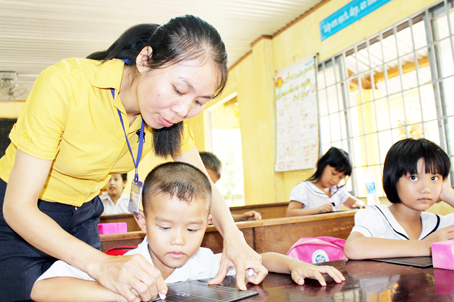 Cô giáo Đồng Thị Loan kèm học sinh viết chữ.