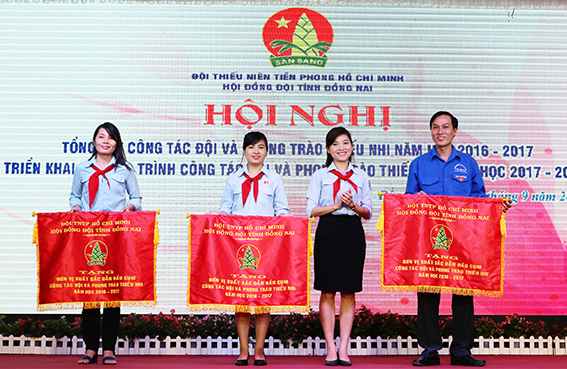 Chủ tịch Hội đồng Đội tỉnh Hồ Hồng Nguyên trao cờ thi đua xuất sắc dẫn đầu cụm cho 3 đơn vị: Xuân Lộc, TP. Biên Hòa và Vĩnh Cửu (lần lượt từ trái sang)