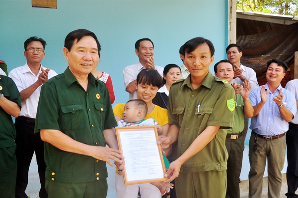Ông Lê Văn Liên (trái), nguyên phó chủ tịch hội cựu chiến binh tỉnh nhiệm kỳ 2012-2017 trao quyết định cấp nhà đồng đội cho hội viên Nguyễn Công Được (ảnh: Đăng Tùng)