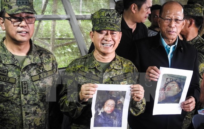 Bộ trưởng Quốc phòng Philippines Delfin Lorenzana (phải) và Chỉ huy trưởng quân đội Philippines Eduardo Ano (giữa) bên ảnh hai thủ lĩnh phiến quân Abu Sayyaf Isnilon Hapilon và Omarkhayam Maute tại cuộc họp báo ở Mindanao ngày 16/10. (Nguồn: AFP/TTXVN)