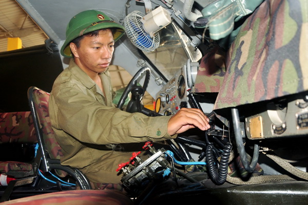 Thiếu úy Hoàng Cao Minh kiểm tra thiết bị trên xe trong quá trình bảo dưỡng.