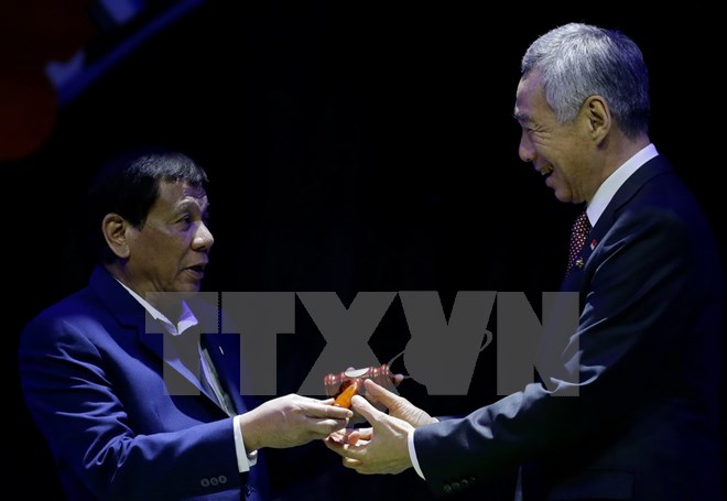 Thủ tướng Singapore Lý Hiển Long (phải) nhận biểu tượng tại lễ chuyển giao chức Chủ tịch luân phiên ASEAN từ Tổng thống Philippines Rodrigo Duterte ở Manila ngày 14/11. (Nguồn: AFP/TTXVN)
