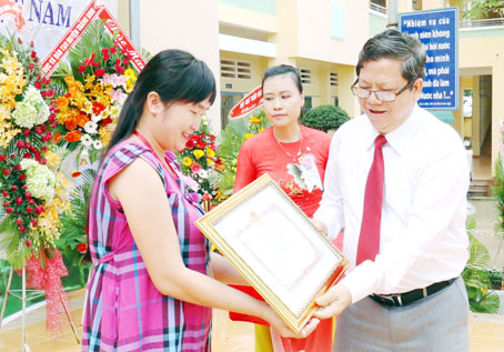 Phó giám đốc Sở GD-ĐT Đào Đức Trình trao bằng khen của UBND tỉnh cho cô Võ Thị Chung, giáo viên của Trường THCS-THPT Bàu Hàm đã hoàn thành xuất sắc nhiệm vụ năm học 2016-2017. Ảnh: V.TUYÊN