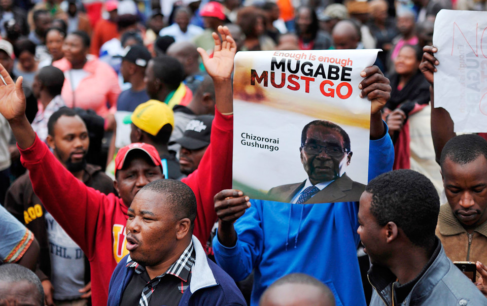 Người dân Zimbabwe tuần hành cầm tranh ảnh, biểu ngữ yêu cầu Tổng thống Mugabe từ chức (Nguồn AP)