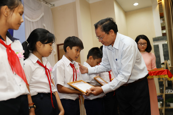 Ông Phạm Văn Cộng, Phó giám đốc Sở Lao động thương binh - xã hội trao học bổng cho các em học sinh