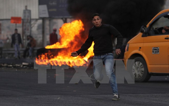 Người biểu tình Palestine ném đá vào binh sỹ Israel tại thành phố Nablus, khu Bờ Tây ngày 10/12. (Nguồn: THX/TTXVN)