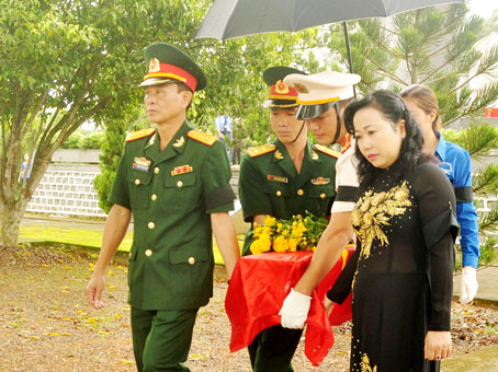 Đại tá Huỳnh Thanh Liêm (bìa trái), Chính ủy Bộ Chỉ huy quân sự tỉnh, đưa hài cốt liệt sĩ tìm thấy ở huyện Định Quán về an nghỉ tại Nghĩa trang liệt sĩ huyện Định Quán vào tháng 7-2017.