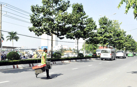 Người đi bộ gánh hàng hóa chạy bàng ngang giữa đường Đồng Khởi, đoạn qua phường Tân Hiệp (TP.Bíên Hòa).