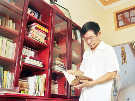 Ông Lê Văn Liên bên tủ sách cất giữ tư liệu cá nhân.