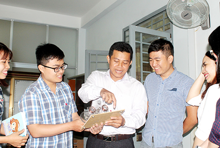 Anh Nguyễn Văn Nghĩa (giữa) giới thiệu với sinh viên về Máy phát điện xoay chiều một pha do anh thực hiện.