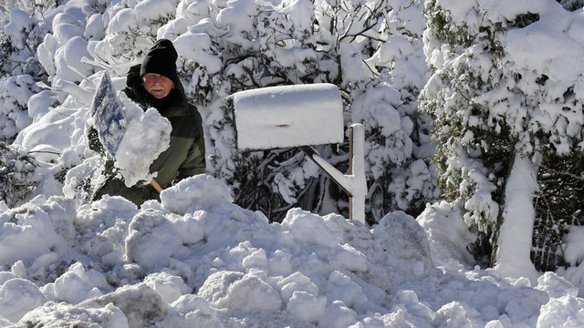 Người dân ở TP Scituate, bang Massuchesetts (Mỹ) đang phải xử lý đống tuyết phủ kín trước nhà - Ảnh: AP