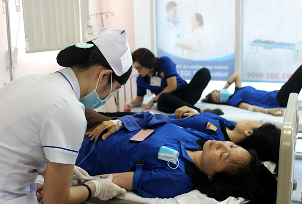 Điều dưỡng Bệnh viện đa khoa Đồng Nai đang tiêm thuốc giảm triệu chứng của ngộ độc thực phẩm cho công nhân. Ảnh: Đặng Ngọc.