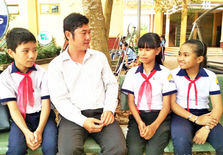 Thầy Trần Văn Lập gặp gỡ, động viên học sinh có hoàn cảnh khó khăn của trường. Ảnh: C.Nghĩa